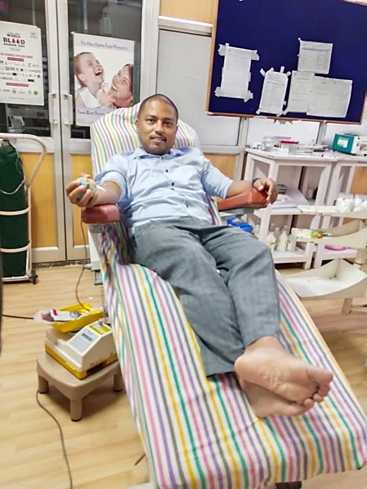 A volunteer donating blood during a World Blood Donor Day camp