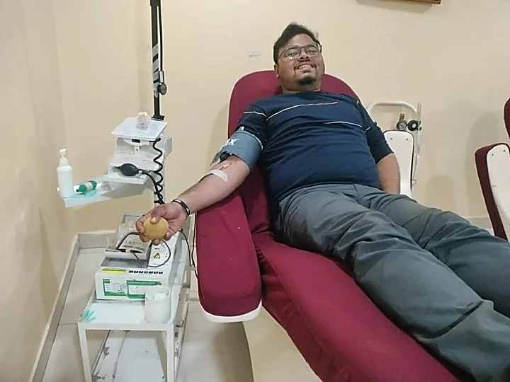 A NANF volunteer donating blood on a hospital donation couch