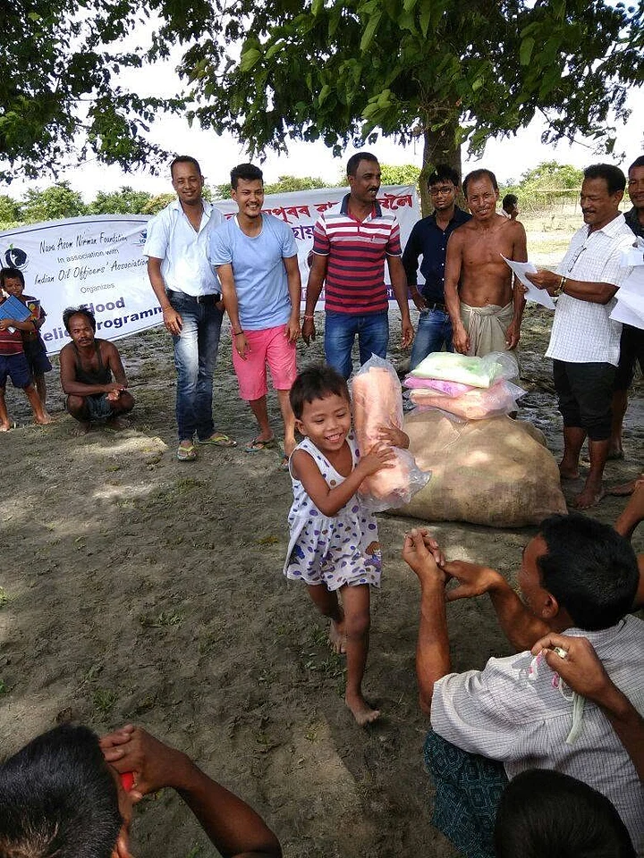A young girl carrying a relief packet during a flood relief distribution