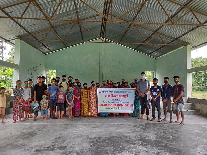 Masked villagers gathered at a community hall for a mask donation drive